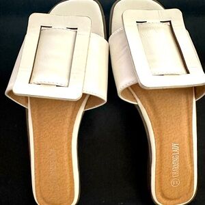 White slip-on flat sandals with buckle